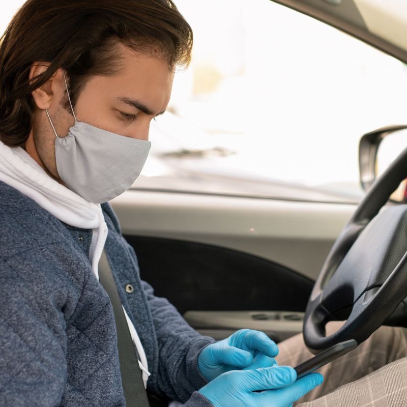 man with mask on in car